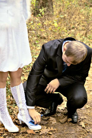 happy bride and groom walking in the autumn parkの写真素材