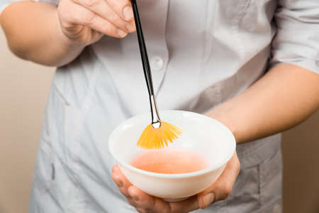Beautician wet brush into the cream before applyingの写真素材