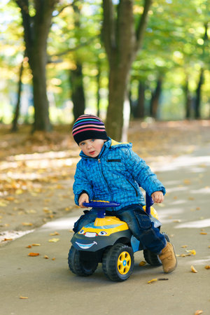 funny beautiful boy driving a car in the parkの写真素材