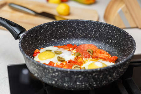 Frying pan with eggs and tomatoesの写真素材