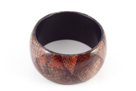 Handmade wooden bracelet with leather snake ornament isolated on white