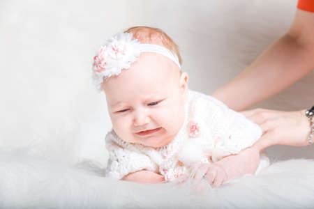 Charming child. Little girl with hat lying on fur rugの写真素材