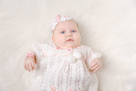 Charming child. Little girl with hat lying on fur rug