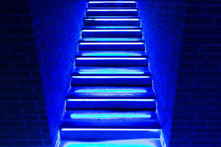 stairs in blue neon lights going up to club or disco.の写真素材