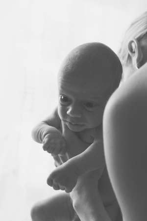 Happy mother holding her baby. Grayscale photo.の写真素材