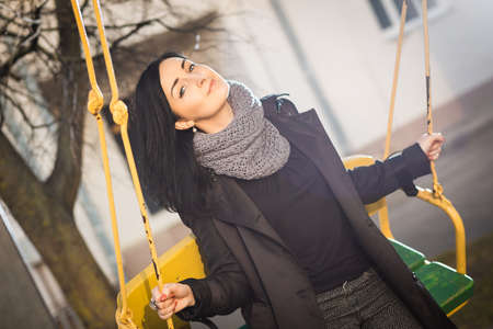 Portrait of beautiful young woman on a swingの写真素材