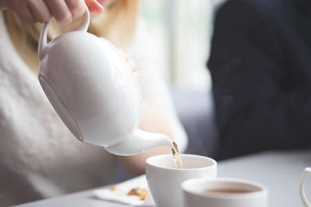 side view of a female pouring teaの写真素材