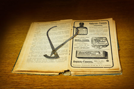 vintage medical instrument and ancient tutorial with yellowed pages
