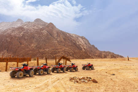 The columns of quads stands on the parking of the Bedouin village in Sahara Egypt.の写真素材