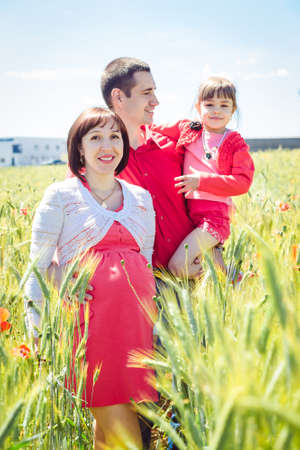 father and little daughter travel on summer wheat fieldの写真素材
