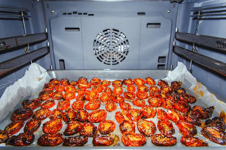Cooking sun-dried tomatoes in the oven in the kitchenの写真素材