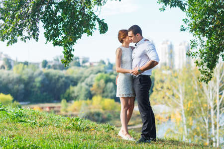 Beautiful young couple embracing near the riverの写真素材