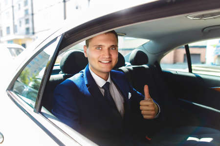 stylish confident young groom makes thumbs up signの写真素材