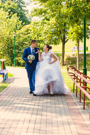 bride and groom is walking together on city park roadの写真素材