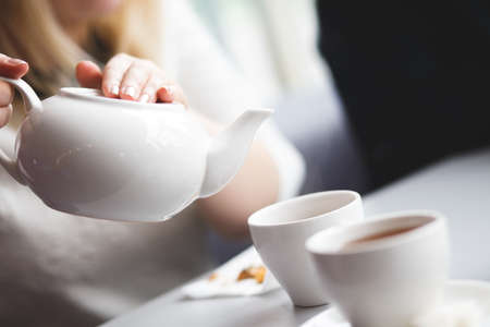 side view of a female pouring teaの写真素材