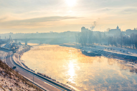 Grodno, Belarus. The sun reflected in the river Neman. Steam over water.