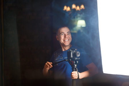 Happy young operator with a dslr camera shoots video in club