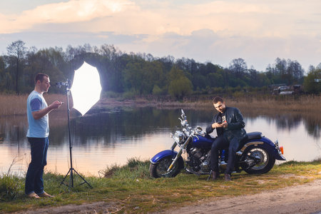 Man sitting on motorcycle on the country road. Backstage.