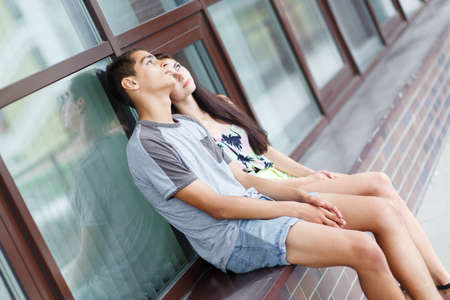 Young couple in love, sitting outdoors. Selective focus.の写真素材