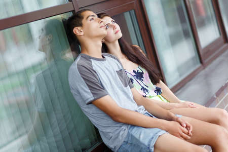 Young couple in love, sitting outdoors. Selective focus.の写真素材