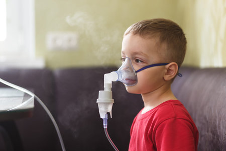 Small boy does therapeutic inhalation using a nebulizerの写真素材