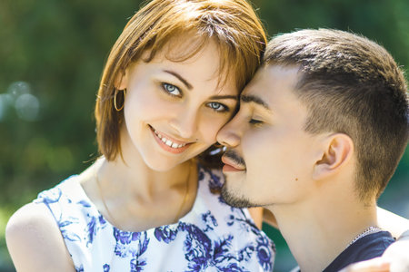 Nice young couple embracing in summer parkの写真素材