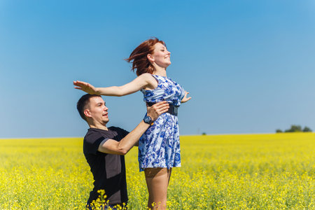 Couple in love, man raises woman up into the skyの写真素材