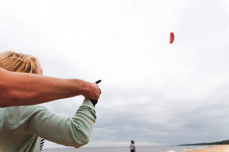 Coach teaches girl control the kite on the seashoreの写真素材