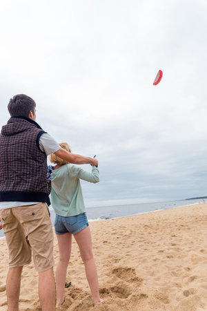 Coach teaches girl control the kite on the seashoreの写真素材