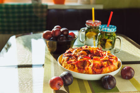 Plum cake and two cups of handmade limonade on tableの写真素材