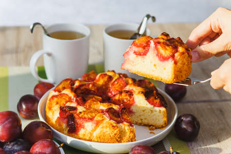 Plum cake and two cups of tea on tableの写真素材