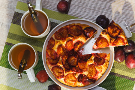 Plum cake and two cups of tea on tableの写真素材