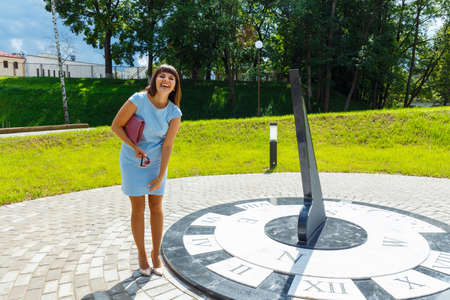 Laughing woman posing near the sun clockの写真素材