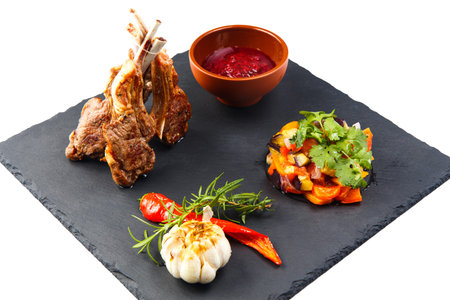 Rack of lamb with tkemali sauce and vegetable Ratatouille. Selective focus. Isolated on white.の写真素材
