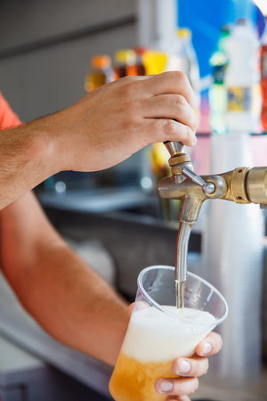 Draft beer pour in a plastic cup from the craneの写真素材