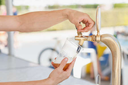 Draft beer pour in a plastic cup from the craneの写真素材