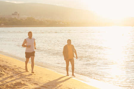 NESSEBAR, BULGARIA - SEP 02: Two men running outdoors on morning beach in Nessebar, Bulgaria at September 02, 2016のeditorial素材