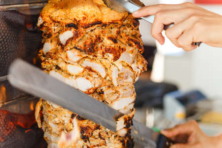 Shawarma meat being cut before making a sandwichの写真素材