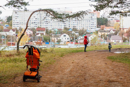 Mother and son walking in autumn Park with views of the cityの写真素材
