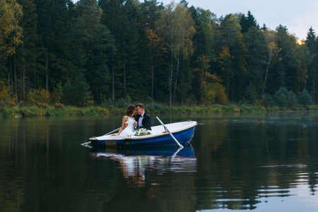 Newly married couple riding on boat on lakeの写真素材