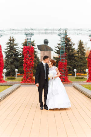 Bride and Groom on walk in autumn parkの写真素材