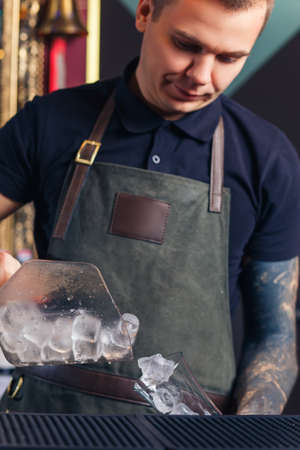 The bartender making cocktail in a nightclub barの写真素材