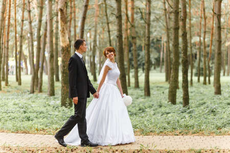 Bride and Groom on walk in autumn parkの写真素材