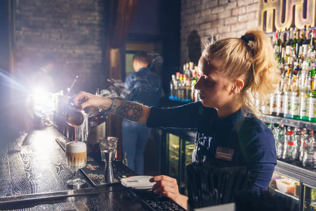 GRODNO, BELARUS - NOV 05: Woman bartender making an alcohol cocktail at the gastrobar HOUDINI in Grodno, Belarus, November 5, 2016のeditorial素材