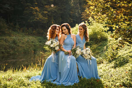 Three beautiful bridesmaids in the park on wedding dayの写真素材