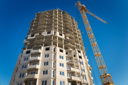 Two tower cranes building working blue sky
