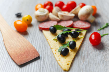 Creative composition of ingredients in the form of a slice of pizzaの写真素材