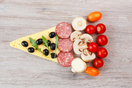 Creative composition of ingredients in the form of a slice of pizzaの写真素材