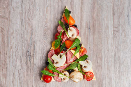 Creative composition of ingredients in the form of a slice of pizzaの写真素材