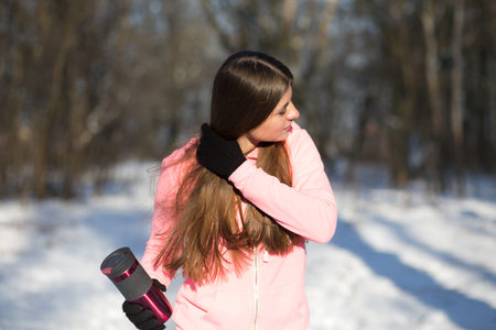 A young girl goes in for sports in winter park. Squats are one of the General developmental exercises.の写真素材